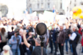Medium: Protest.,Political,Rally.,Demonstration.,Microphone,In,Focus,,Blurred,Crowd,In